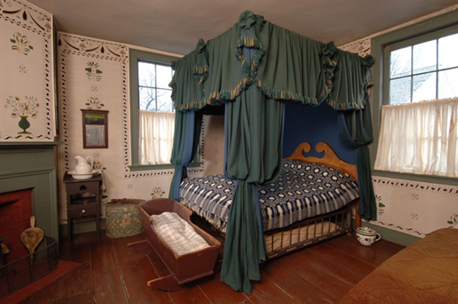 Bed hanging from worsted wool in the style of 1835 with polychrome
fringe and rosette and bells.